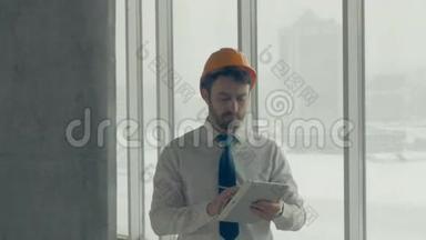 建筑大师、戴安全帽的商人在一个建筑工地内用平板电脑检查<strong>施工进度</strong>。 滑块